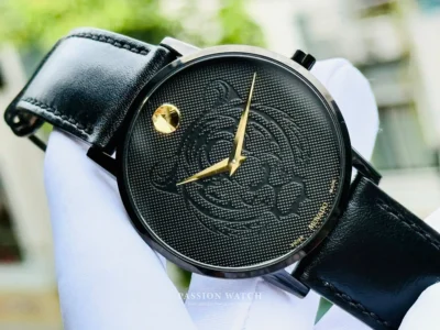 movado 0607586 3 Movado 0607586 nhìn trực diện, mặt số màu đen với họa tiết mặt con hổ độc đáo, kim chỉ giờ màu vàng nổi bật trên nền dial, logo tròn ở góc 12h màu vàng tạo điểm nhấn